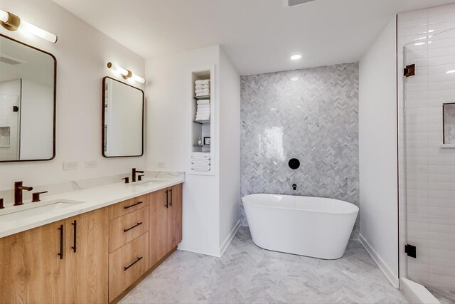 500 W Superior St Unit 612, Chicago, IL 60654 - bathroom featuring double vanity, a freestanding tub, baseboards, an accent wall, and a shower