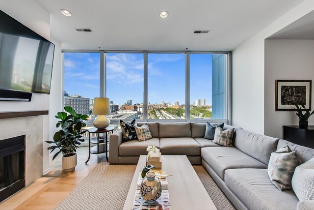 500 W Superior St Unit 612, Chicago, IL 60654 - living area with a view of city, a premium fireplace, recessed lighting, wood finished floors, and a wall of windows
