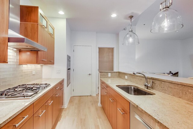 500 W Superior St Unit 612, Chicago, IL 60654 - kitchen with a sink, stainless steel gas stovetop, wall chimney exhaust hood, light wood-style floors, and light stone counters