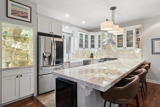 1012 S Loomis St Unit F, Chicago, IL 60607 - kitchen featuring stainless steel appliances, beverage cooler, wall chimney range hood, a sink, and a peninsula