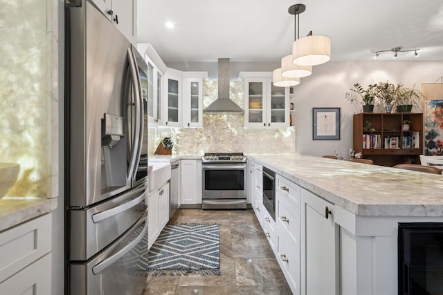 1012 S Loomis St Unit F, Chicago, IL 60607 - kitchen with stainless steel appliances, wall chimney range hood, a peninsula, and light countertops