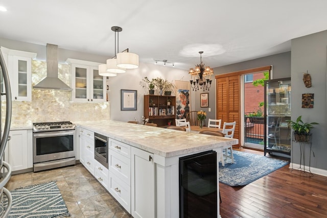 1012 S Loomis St Unit F, Chicago, IL 60607 - kitchen featuring wine cooler, stainless steel appliances, wall chimney exhaust hood, a peninsula, and light countertops