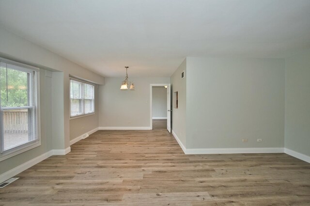 7410 162nd St, Tinley Park, IL 60477 - spare room featuring a chandelier, wood finished floors, and baseboards