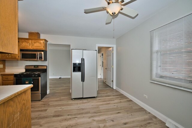 7410 162nd St, Tinley Park, IL 60477 - kitchen featuring appliances with stainless steel finishes, a ceiling fan, light wood-style flooring, baseboards, and light countertops