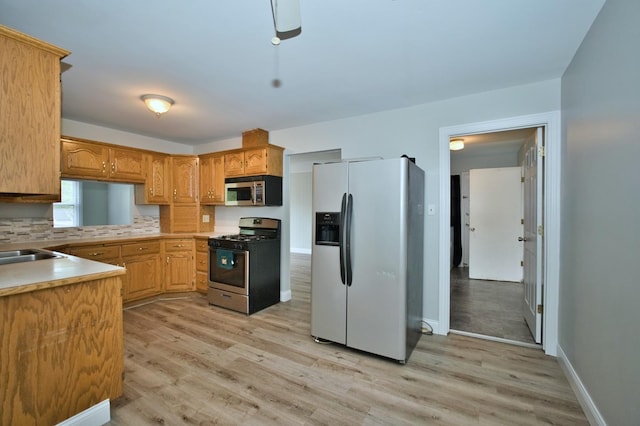 7410 162nd St, Tinley Park, IL 60477 - kitchen with appliances with stainless steel finishes, light wood-style floors, decorative backsplash, and light countertops