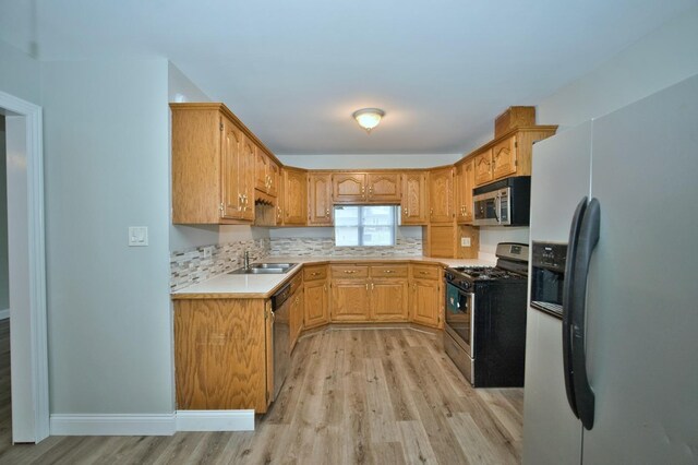 7410 162nd St, Tinley Park, IL 60477 - kitchen featuring appliances with stainless steel finishes, light wood-style floors, a sink, light countertops, and backsplash