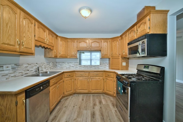 7410 162nd St, Tinley Park, IL 60477 - kitchen with stainless steel appliances, a sink, light wood-style flooring, backsplash, and light countertops