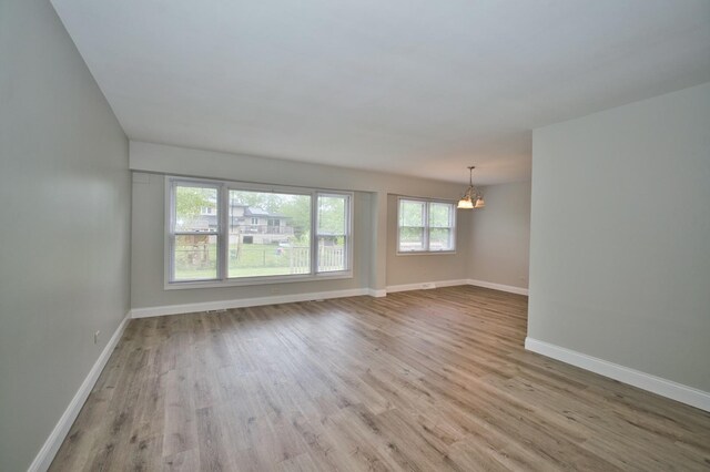 7410 162nd St, Tinley Park, IL 60477 - spare room featuring a chandelier, wood finished floors, and baseboards