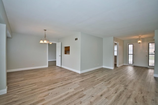 7410 162nd St, Tinley Park, IL 60477 - unfurnished living room featuring a chandelier, wood finished floors, and baseboards