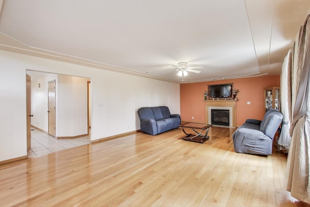 1347 Rainbow Cir, Manteno, IL 60950 - unfurnished living room with a glass covered fireplace, ceiling fan, wood finished floors, and baseboards