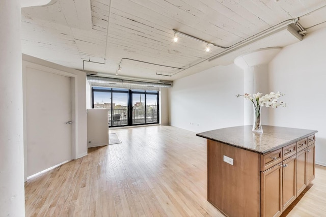 1525 S Sangamon St Unit 312, Chicago, IL 60608 - kitchen featuring track lighting, light wood-type flooring, open floor plan, and stone countertops