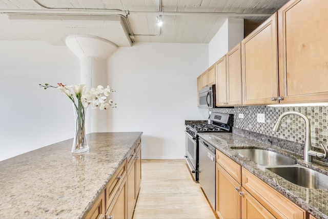 1525 S Sangamon St Unit 312, Chicago, IL 60608 - kitchen with a sink, appliances with stainless steel finishes, decorative backsplash, light wood-style flooring, and stone counters