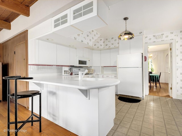 671 Euclid Ave, Glen Ellyn, IL 60137 - kitchen with white appliances, a peninsula, wallpapered walls, a breakfast bar, and light countertops