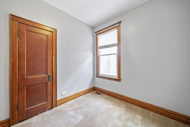 carpeted empty room featuring baseboards
