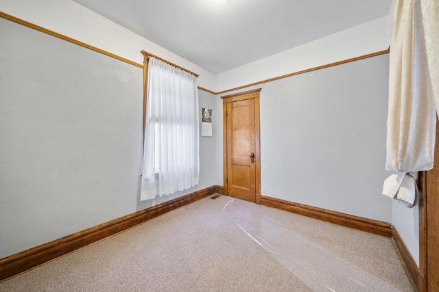 carpeted empty room with baseboards
