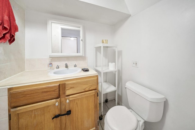 bathroom with toilet, vanity, and tile patterned floors