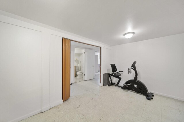 workout room with baseboards and tile patterned floors