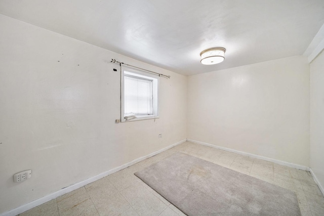 unfurnished room with baseboards