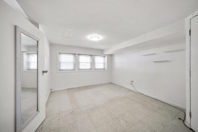 empty room featuring tile patterned floors and baseboards