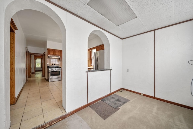 unfurnished room featuring baseboards and light colored carpet