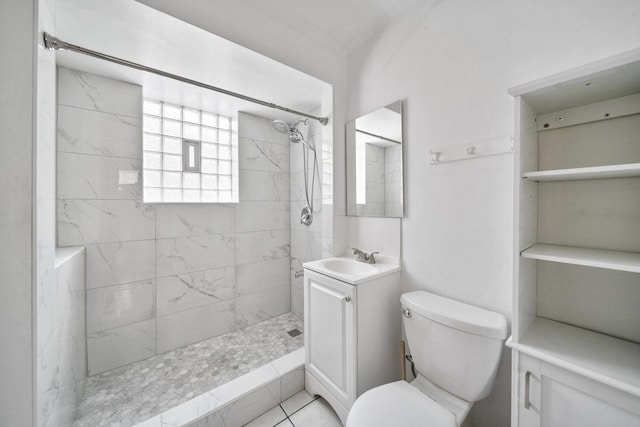 full bath featuring a tile shower, toilet, and vanity