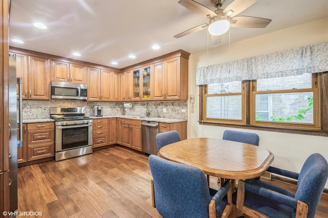 5639 W Montrose Ave, Chicago, IL 60634 - kitchen with appliances with stainless steel finishes, dark wood-style flooring, a sink, backsplash, and a ceiling fan