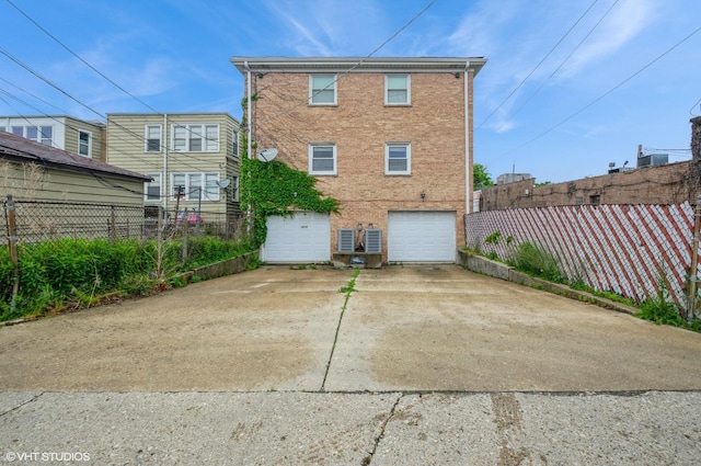 5639 W Montrose Ave, Chicago, IL 60634 - back of house with an attached garage, brick siding, and concrete driveway