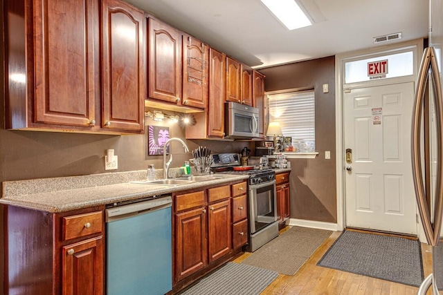 5942 S King Dr Unit 2N, Chicago, IL 60637 - kitchen with stainless steel appliances, a sink, light wood-type flooring, light countertops, and baseboards