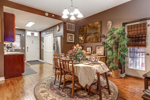 5942 S King Dr Unit 2N, Chicago, IL 60637 - dining area featuring a chandelier, hardwood / wood-style floors, and baseboards