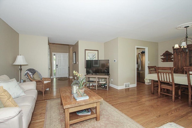 196 Shoreline Rd, Lake Barrington, IL 60010 - living room featuring a chandelier, light wood-type flooring, and baseboards
