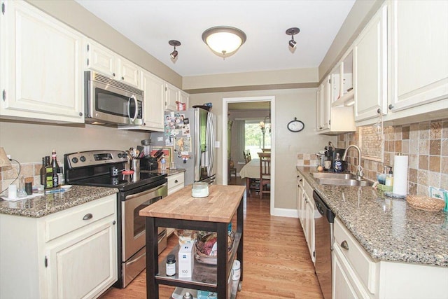 196 Shoreline Rd, Lake Barrington, IL 60010 - kitchen with stainless steel appliances, a sink, decorative backsplash, light wood-style floors, and light stone countertops