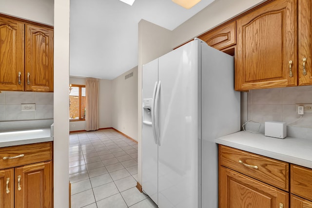 1212 Ashford Ln, Joliet, IL 60431 - kitchen with white fridge with ice dispenser, light tile patterned flooring, tasteful backsplash, light countertops, and lofted ceiling