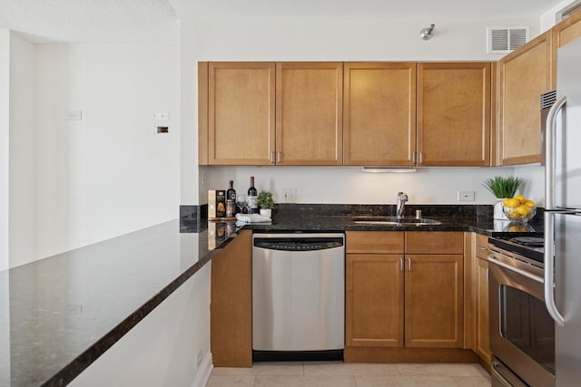 474 N Lake Shore Dr Unit 5306, Chicago, IL 60611 - kitchen with stainless steel appliances, dark stone countertops, light tile patterned floors, and brown cabinetry