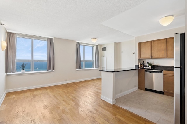 474 N Lake Shore Dr Unit 5306, Chicago, IL 60611 - kitchen with appliances with stainless steel finishes, a peninsula, dark countertops, open floor plan, and brown cabinetry