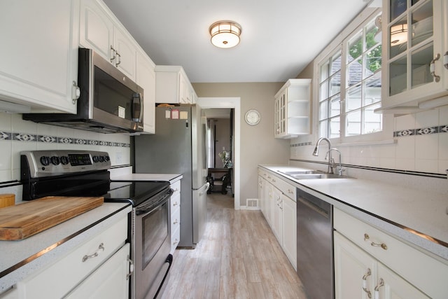 39270 N Lake Ave, Lake Villa, IL 60046 - kitchen featuring stainless steel appliances, a sink, light wood finished floors, light countertops, and backsplash