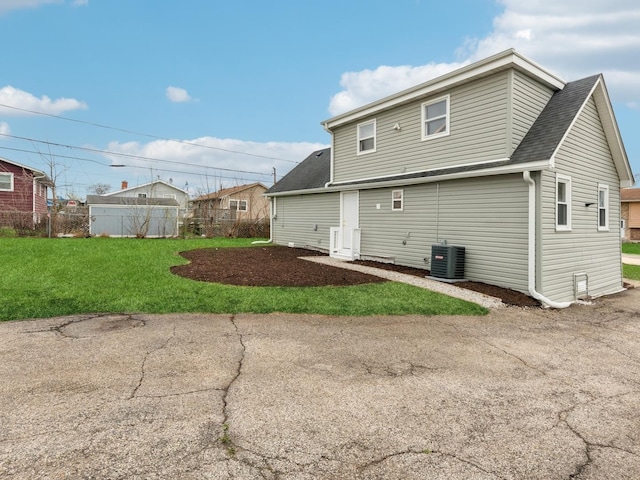 520 W Pheasant Ct, Round Lake Beach, IL 60073 - back of property with central AC unit and a shingled roof