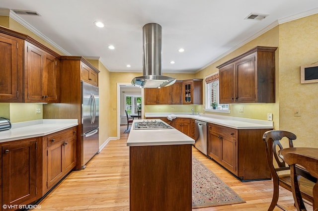 1117 Keystone Ave, River Forest, IL 60305 - kitchen with appliances with stainless steel finishes, island range hood, a kitchen island, light wood-style flooring, and ornamental molding