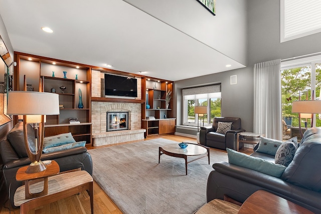 21186 Sage Brush Ln, Mokena, IL 60448 - living room featuring wood finished floors, a glass covered fireplace, built in features, and recessed lighting