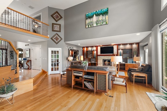 21186 Sage Brush Ln, Mokena, IL 60448 - living area with a high ceiling, light wood finished floors, a fireplace, stairway, and baseboards
