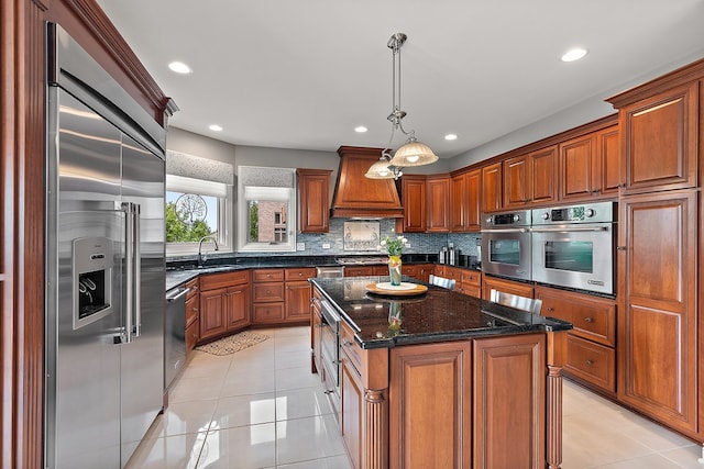 21186 Sage Brush Ln, Mokena, IL 60448 - kitchen with stainless steel appliances, premium range hood, a sink, light tile patterned floors, and brown cabinetry