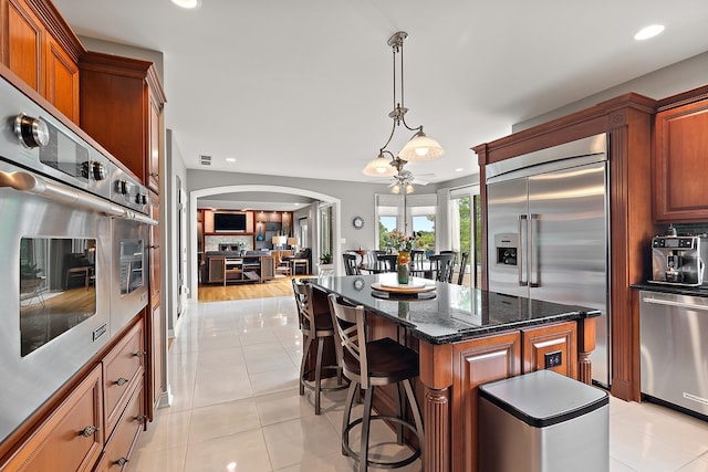 21186 Sage Brush Ln, Mokena, IL 60448 - kitchen featuring appliances with stainless steel finishes, arched walkways, light tile patterned flooring, recessed lighting, and a breakfast bar area