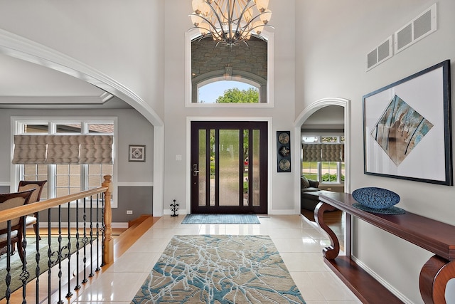 21186 Sage Brush Ln, Mokena, IL 60448 - tiled foyer entrance with arched walkways, a chandelier, a towering ceiling, and baseboards