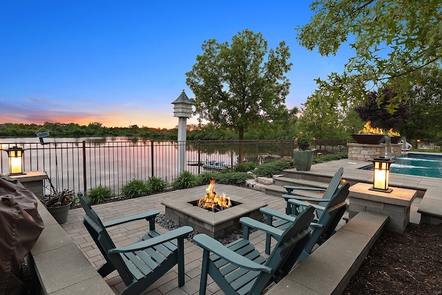 21186 Sage Brush Ln, Mokena, IL 60448 - patio terrace at dusk featuring a fire pit, a water view, and a patio area