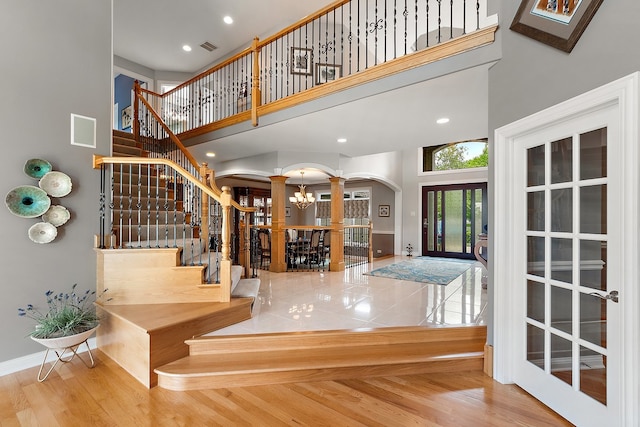 21186 Sage Brush Ln, Mokena, IL 60448 - stairway featuring ornate columns, a towering ceiling, arched walkways, baseboards, and recessed lighting