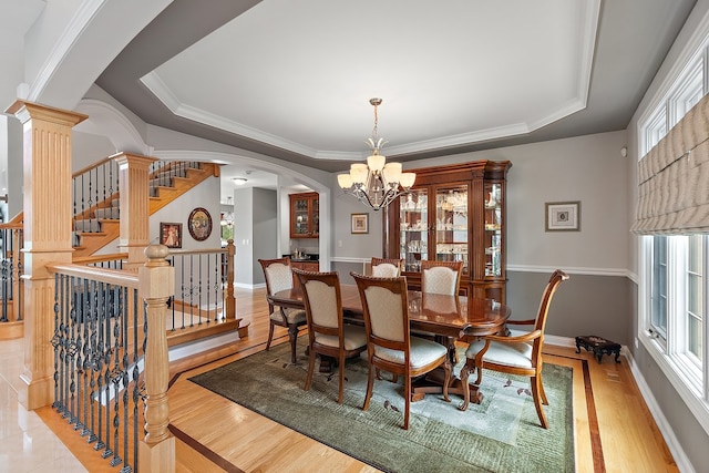 21186 Sage Brush Ln, Mokena, IL 60448 - dining area with arched walkways, a chandelier, a raised ceiling, baseboards, and ornamental molding