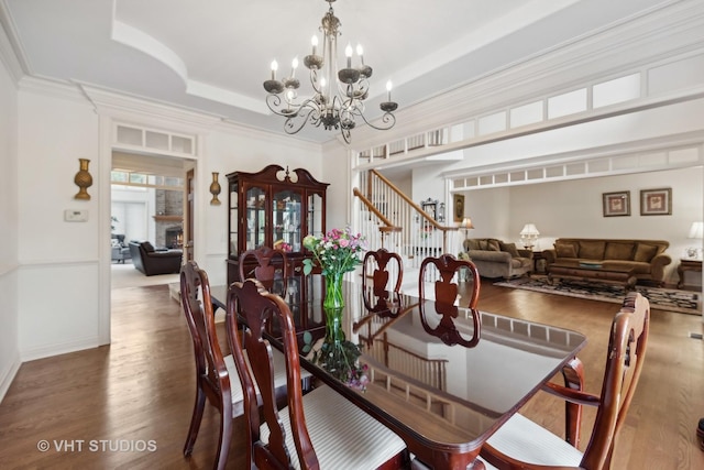 3620 Schillinger Ct, Naperville, IL 60564 - dining space featuring wood finished floors, a chandelier, stairs, ornamental molding, and a raised ceiling