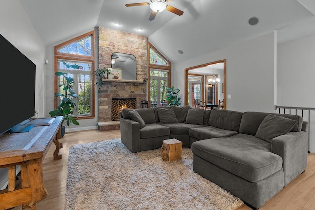 10920 Preservation Way, Richmond, IL 60071 - living area with lofted ceiling, a ceiling fan, a chandelier, a stone fireplace, and light wood-style floors