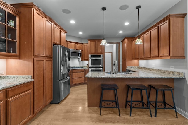 10920 Preservation Way, Richmond, IL 60071 - kitchen featuring stainless steel appliances, brown cabinets, light wood-style floors, a peninsula, and recessed lighting