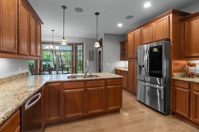 10920 Preservation Way, Richmond, IL 60071 - kitchen featuring stainless steel appliances, brown cabinetry, a sink, light wood-style flooring, and a peninsula