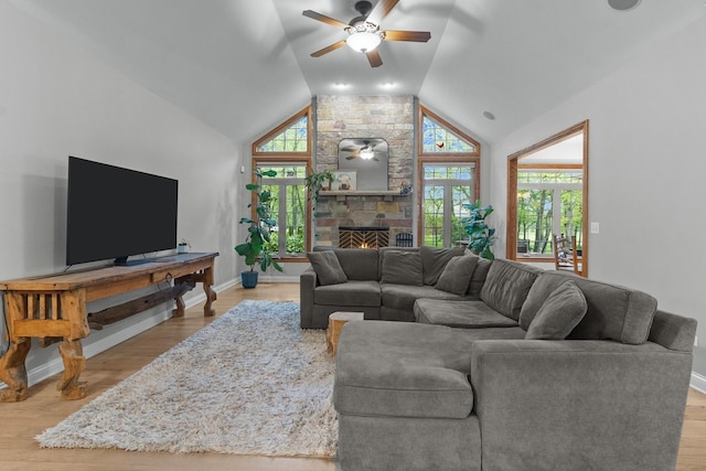 10920 Preservation Way, Richmond, IL 60071 - living room featuring ceiling fan, plenty of natural light, lofted ceiling, a stone fireplace, and wood finished floors